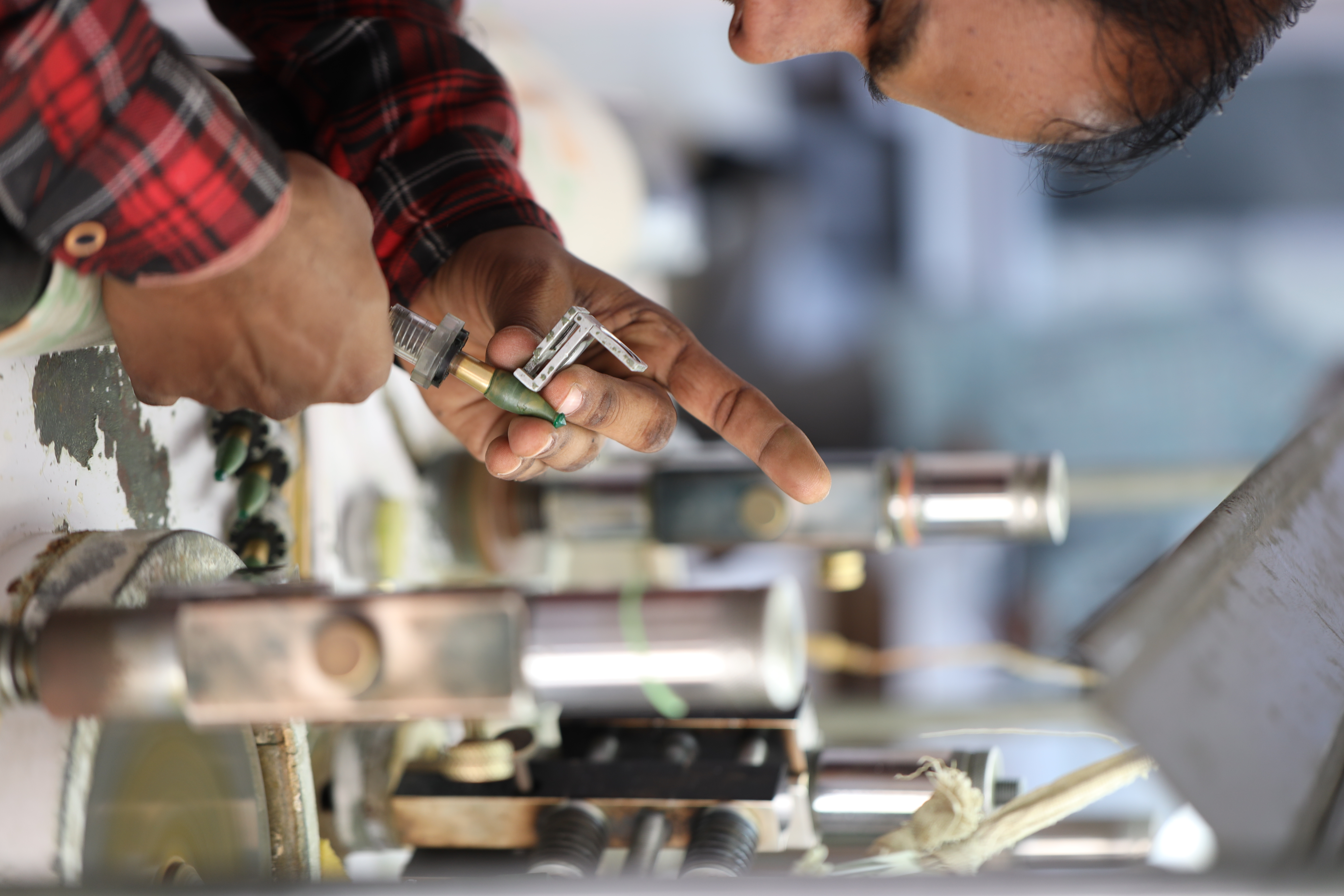 A master craftsman cutting an emerald on a traditional lapidary wheel