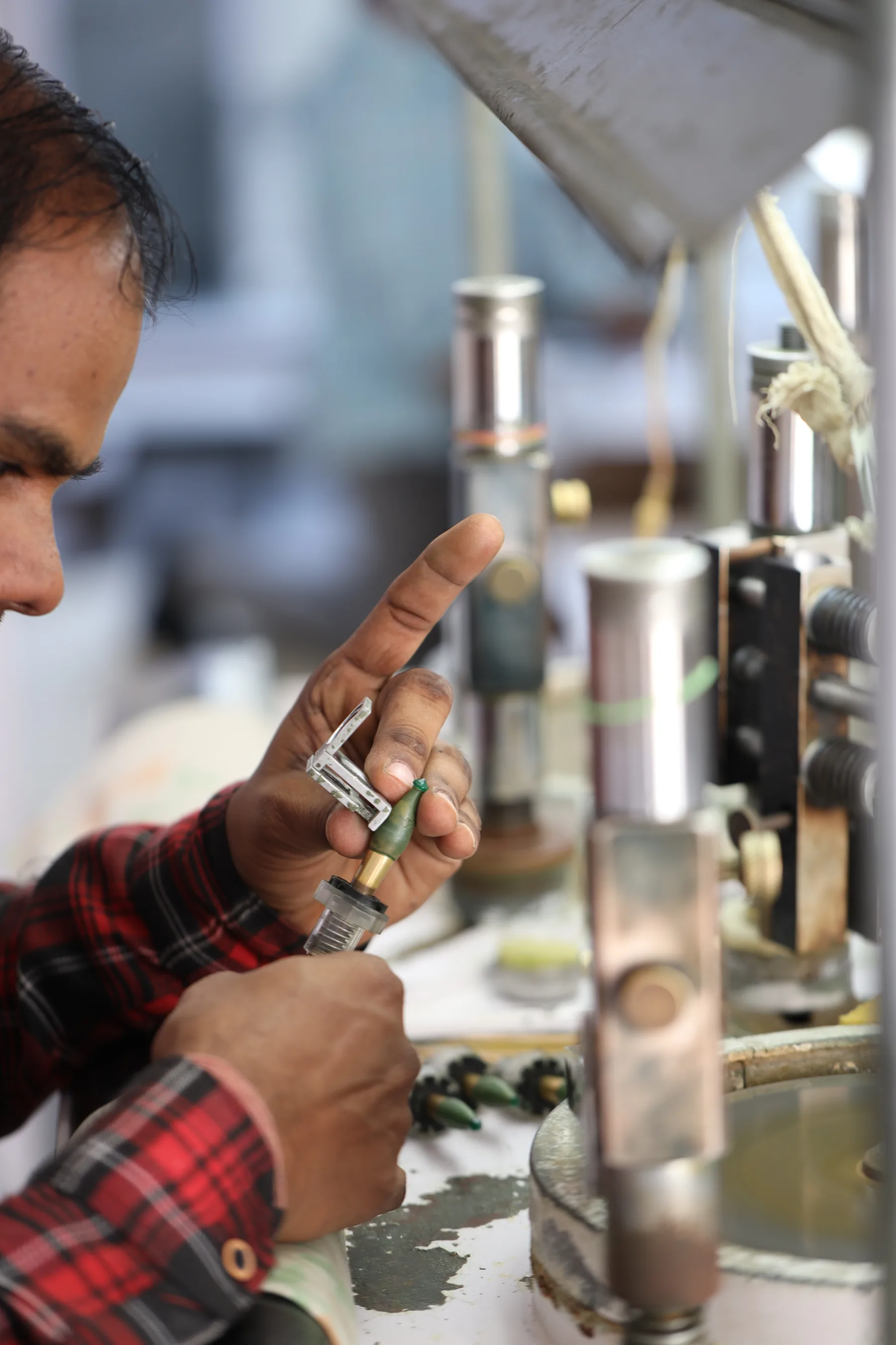 A master craftsman cutting an emerald on a traditional lapidary wheel